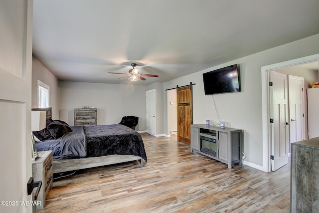 260 Selkirk Rd, Williamsport, PA 17701 - bedroom with a barn door, light wood-style flooring, baseboards, a ceiling fan, and baseboard heating