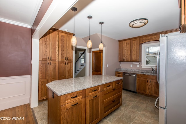 kitchen featuring a sink, freestanding refrigerator, brown cabinets, dishwasher, and decorative light fixtures