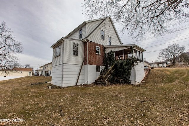 exterior space with brick siding and a yard