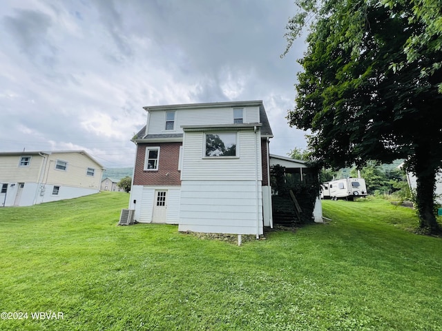 back of property with a lawn and central AC unit