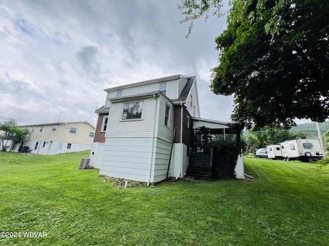 rear view of property with a yard and central AC unit