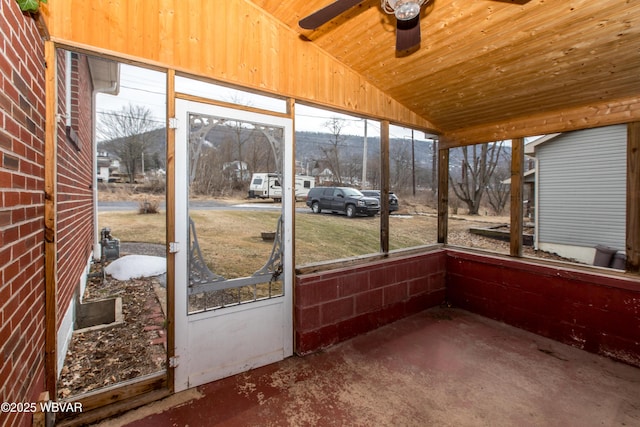 unfurnished sunroom with vaulted ceiling, ceiling fan, and plenty of natural light