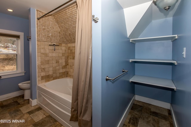 bathroom with shower / bath combo, stone finish floor, baseboards, and toilet