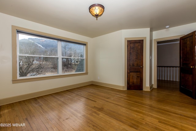 unfurnished room with baseboards and wood finished floors