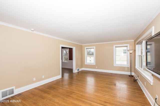 unfurnished room featuring crown molding, light wood finished floors, visible vents, and baseboards