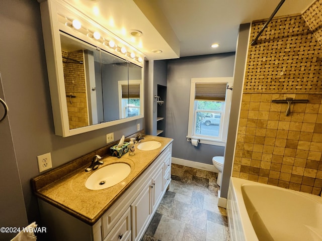 full bathroom with vanity, tiled shower / bath combo, and toilet