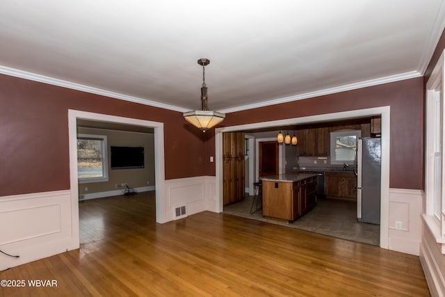 kitchen featuring freestanding refrigerator, open floor plan, visible vents, and hanging light fixtures