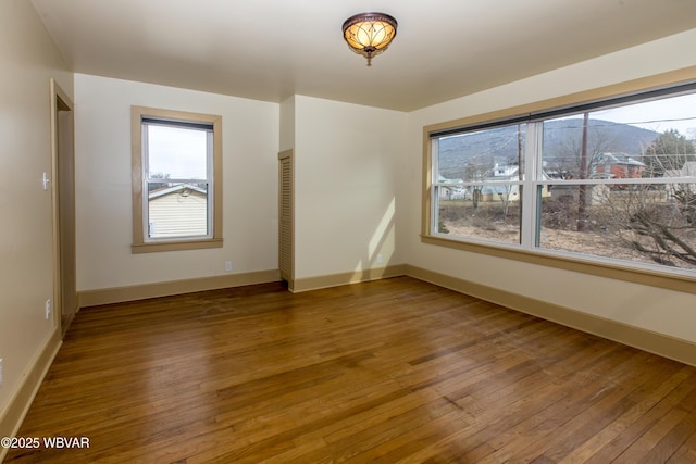 spare room featuring wood finished floors and baseboards