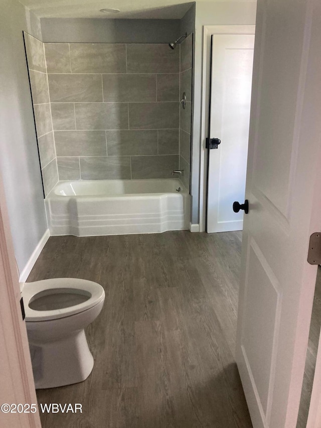 215 E 8th St, Watsontown, PA 17777 - bathroom with toilet, wood finished floors, shower / tub combination, and baseboards