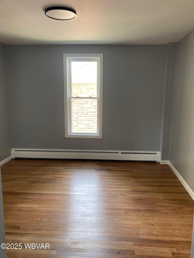 215 E 8th St, Watsontown, PA 17777 - unfurnished room featuring baseboard heating, wood finished floors, and baseboards