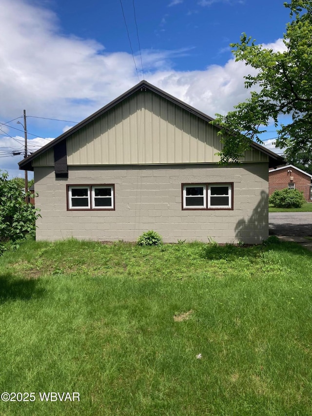 215 E 8th St, Watsontown, PA 17777 - view of side of home with board and batten siding, a lawn, and concrete block siding