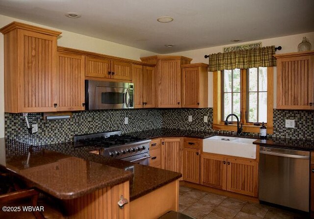 796 Ellis Artley Rd, Muncy, PA 17756 - kitchen with stainless steel appliances, a sink, decorative backsplash, a peninsula, and dark stone countertops