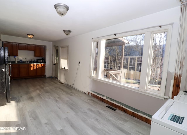 interior space featuring light hardwood / wood-style floors, washer and clothes dryer, and sink