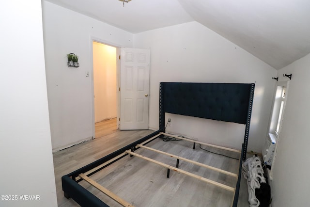 bedroom featuring wood-type flooring and lofted ceiling