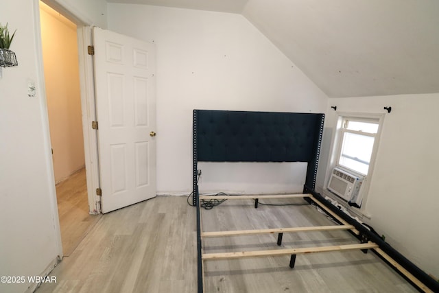 unfurnished bedroom featuring light hardwood / wood-style floors and vaulted ceiling