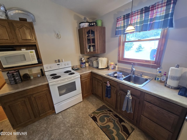 kitchen with pendant lighting, white appliances, light tile patterned floors, and sink