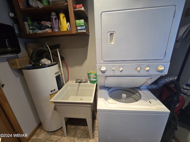 clothes washing area featuring electric water heater and stacked washer / drying machine