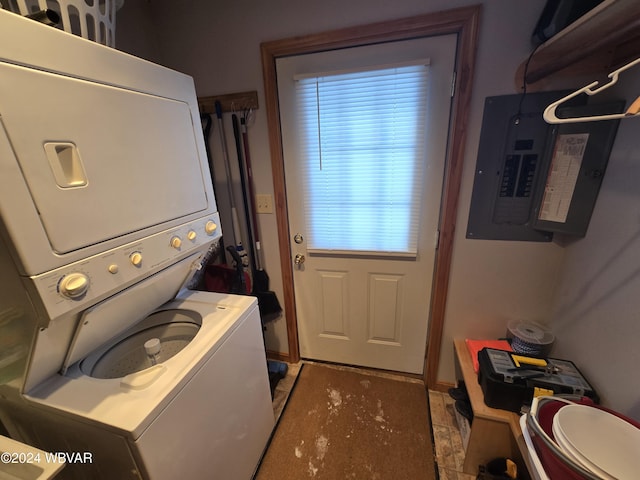 clothes washing area featuring stacked washer and dryer and electric panel