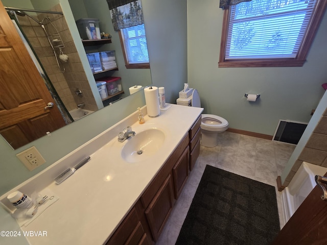 full bathroom with tile patterned floors, vanity, tiled shower / bath combo, and toilet