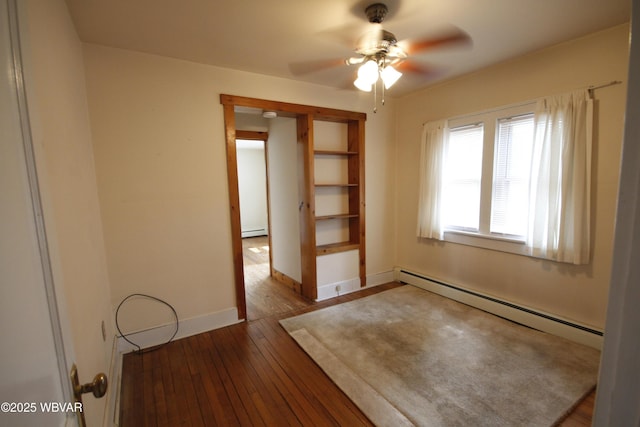 spare room with a baseboard radiator, wood-type flooring, ceiling fan, and baseboards