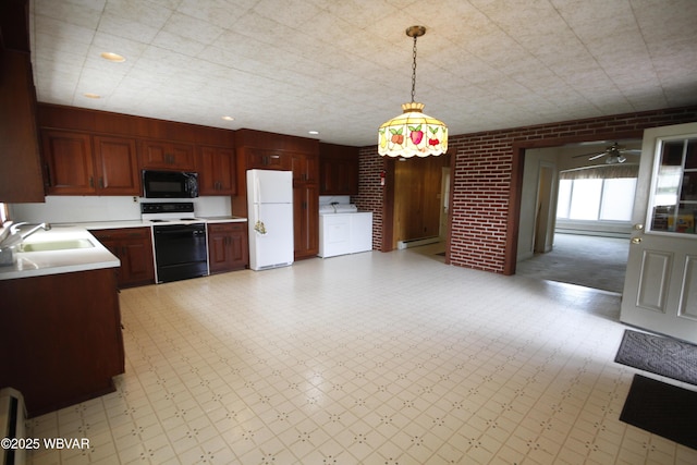 kitchen featuring range with electric stovetop, freestanding refrigerator, black microwave, a sink, and light countertops