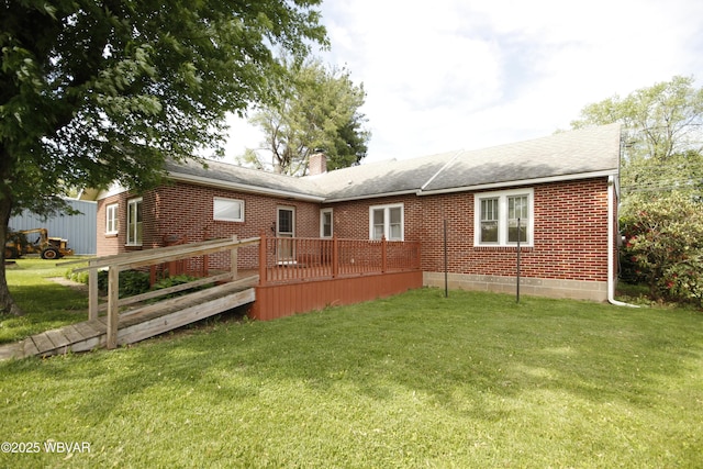 rear view of property featuring a wooden deck, brick siding, a lawn, and a chimney