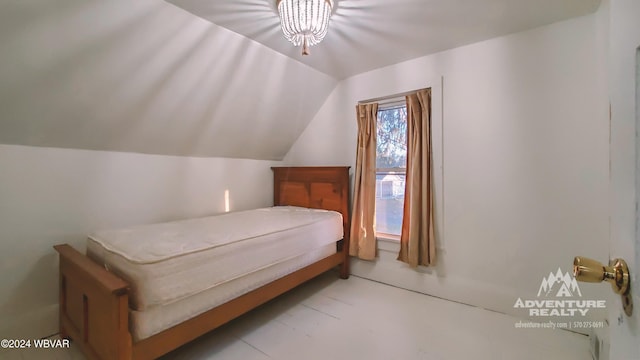 bedroom with lofted ceiling and an inviting chandelier