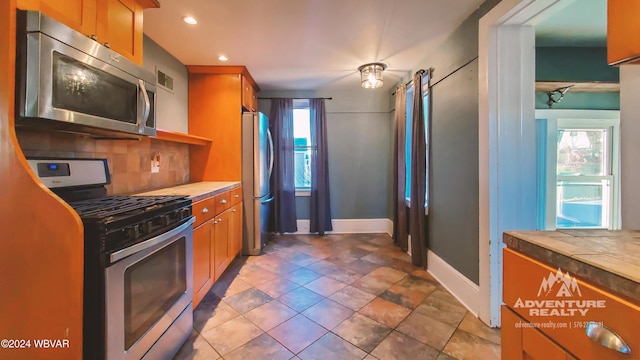 kitchen with decorative backsplash, a healthy amount of sunlight, and appliances with stainless steel finishes