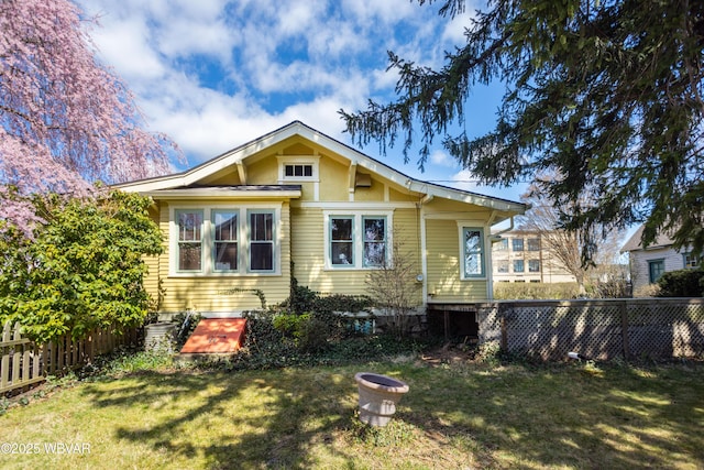 view of front of property with a front yard and fence