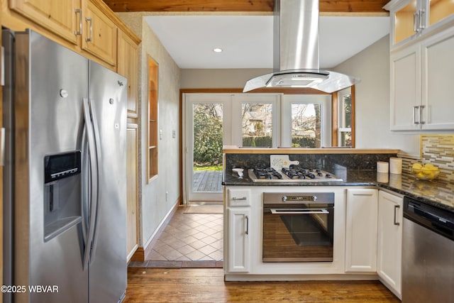 kitchen with recessed lighting, glass insert cabinets, decorative backsplash, island range hood, and appliances with stainless steel finishes