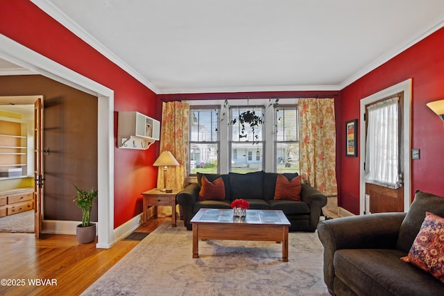 living area with crown molding, wood finished floors, and baseboards