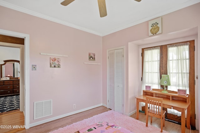 bedroom featuring a closet, ornamental molding, visible vents, wood finished floors, and baseboards