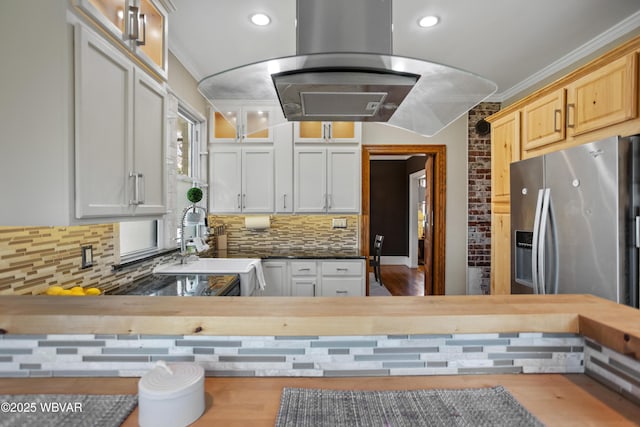 kitchen with glass insert cabinets, a sink, ornamental molding, island exhaust hood, and decorative backsplash