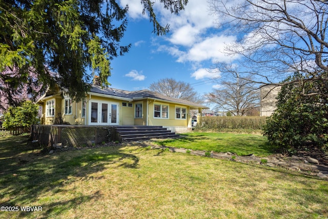 back of property featuring a yard and french doors