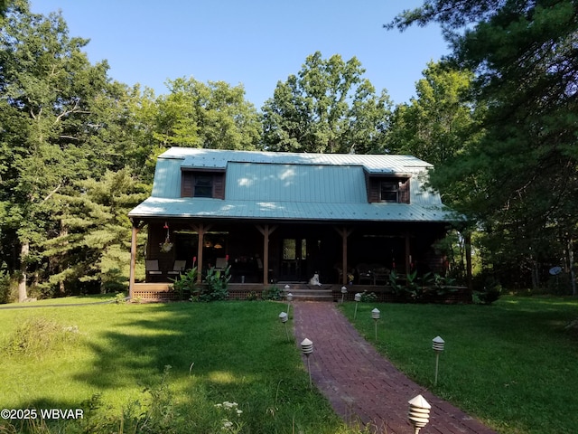 view of front facade featuring covered porch, a front lawn, and metal roof