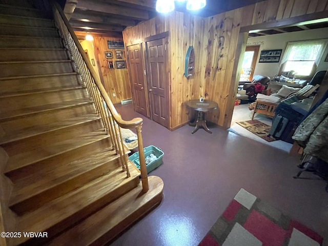 living area featuring stairs and wooden walls