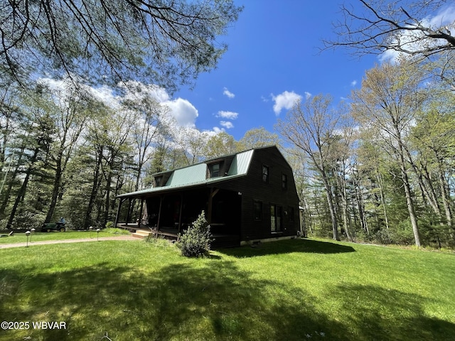 view of front of house with a front lawn, a gambrel roof, and metal roof