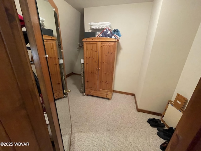 hallway with light colored carpet and baseboards