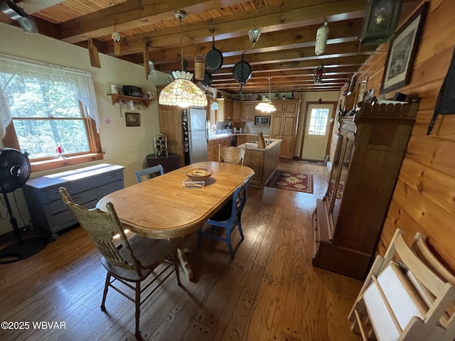 dining space with wood-type flooring, beam ceiling, and wooden ceiling