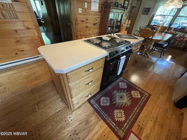 kitchen with black / electric stove, wood-type flooring, light countertops, and a center island