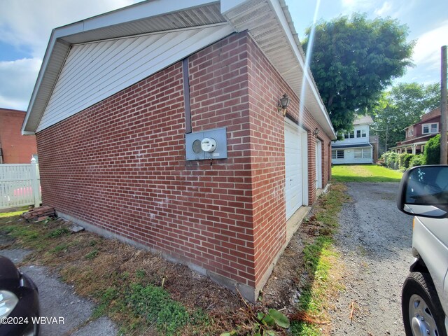 view of side of home featuring an outbuilding and a garage