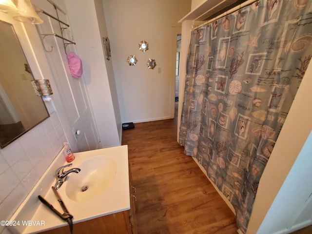 bathroom featuring decorative backsplash, vanity, and hardwood / wood-style flooring