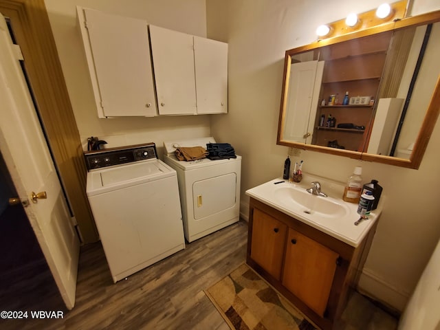 laundry room featuring wood-type flooring, washer and clothes dryer, and sink