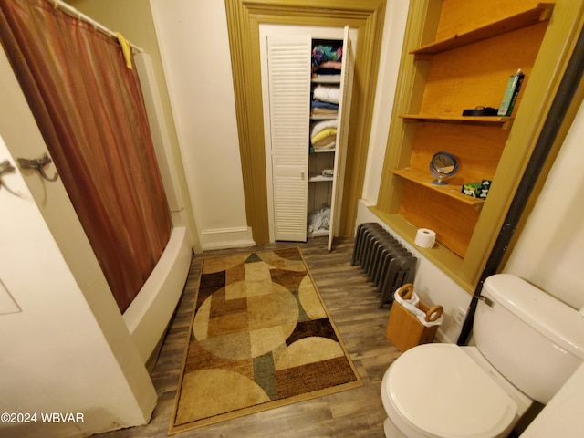 bathroom featuring radiator, toilet, shower / tub combo, and hardwood / wood-style flooring