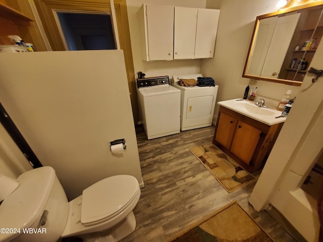 bathroom with toilet, hardwood / wood-style floors, vanity, and independent washer and dryer