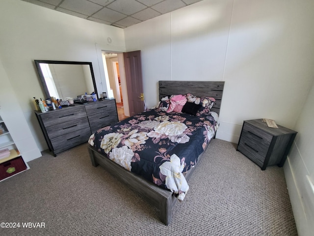 carpeted bedroom featuring a drop ceiling