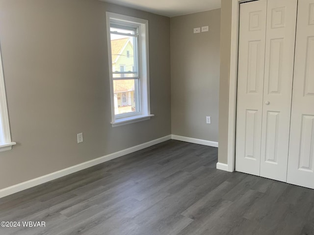 unfurnished bedroom featuring dark hardwood / wood-style flooring and a closet