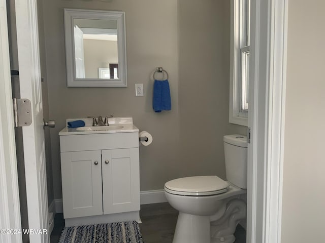 bathroom featuring vanity, hardwood / wood-style flooring, and toilet