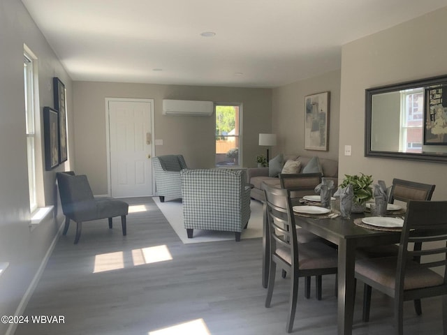 dining space featuring an AC wall unit and hardwood / wood-style floors