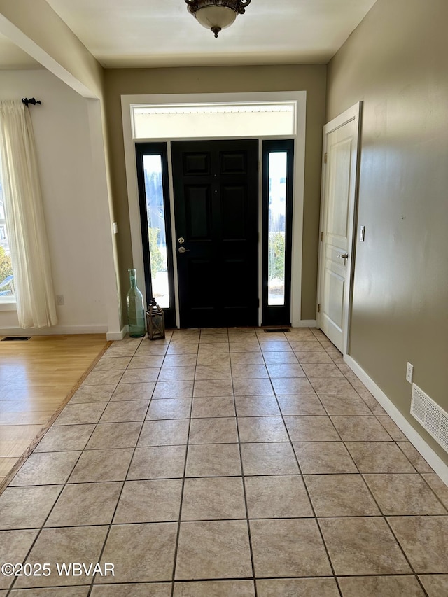 foyer featuring light tile patterned flooring and plenty of natural light